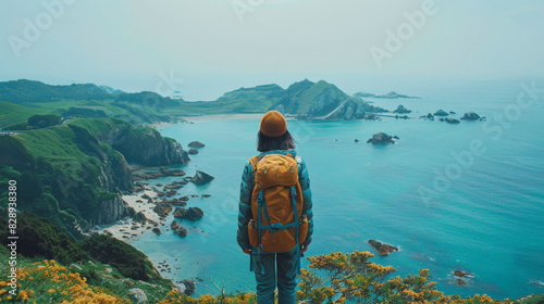 A lone traveler with an orange backpack gazes out at a serene coastline of rocky islands, capturing a peaceful moment of natural beauty.
