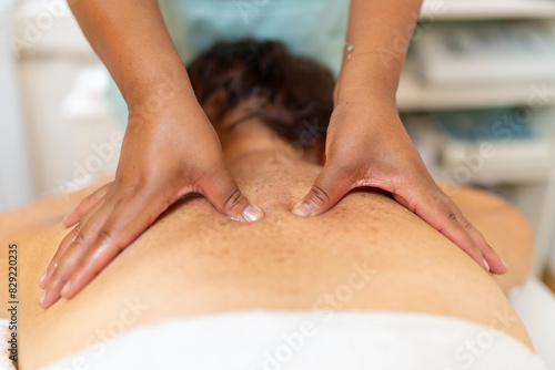 Masseur pressuring pain points of the back of a woman