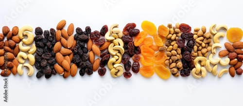 A variety of dried fruits and nuts arranged on a white dish including raisins dried apricots prunes dates cherries cashews almonds and walnuts The close up view from above showcases this delightful a
