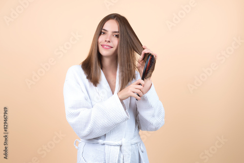 Woman combing her hair. Cares about a healthy and clean hair. Beauty hair salon concept. Girl with a comb in studio. Brushing hair, smooth soft silky hairs effect keratin. Hairs brush.