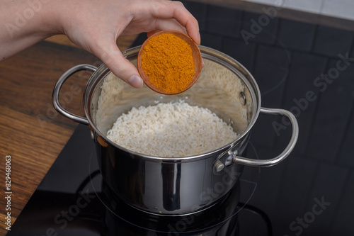 Dodawać przyprawę curry do ryżu w garnku