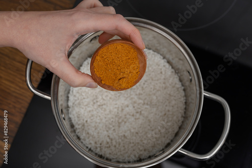 Ryż curry, przyprawa curry z kurkumą dodawana do garnka z gotującym się ryżem 