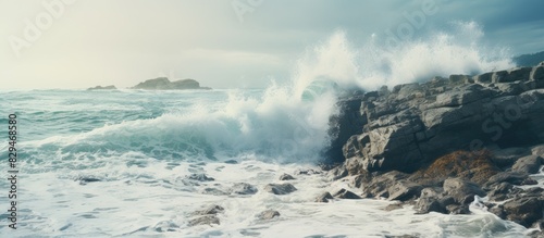 An image with ocean waves crashing against a rocky shoreline with copy space