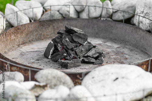 Stos węgla drzewnego ułożony w palenisku grilla gotowy do rozpalania 