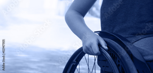 Boy's hand on the wheel of a wheelchair