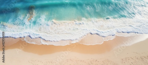 Aerial photograph of the sandy beach with a panoramic view of the ocean and waves offering a serene coastal vista with copy space image