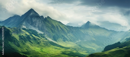 Mountain scenery with a green hue set against a cloudy sky perfect for use as a background in photographs with copy space image