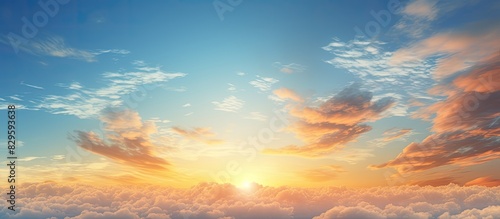 An incredible summer sunset view with a beautiful yellow and orange sky above a sun drenched blue sky with clouds providing ample copy space image