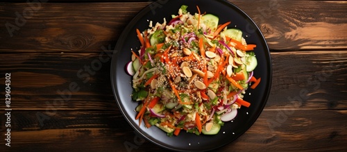 A healthy vegan concept featuring a fresh cabbage salad with organic vegetables and sesame seeds on a ceramic plate Presented on a wooden background in a top view flat lay style highlighting a copy sp