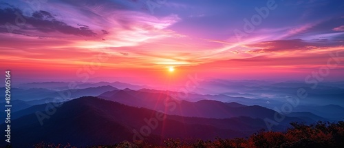 A breathtaking sunrise over a mountain range, with vibrant pink and blue hues in the sky.