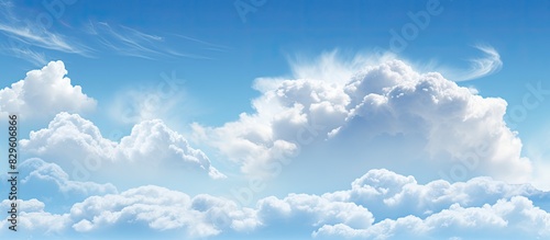 A serene blue sky with fluffy white clouds is an ideal choice for a background image on a website or in artwork due to its calming and peaceful nature. Copy space image