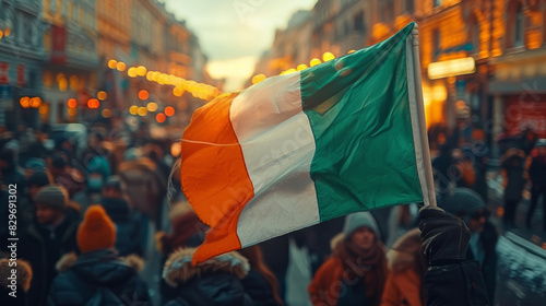 A bustling crowd at a street rally is unified by the waving Irish flag, symbolizing patriotism and unity