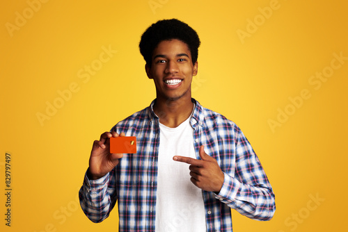 Happy Guy Holding Credit Card and Point on It, Peased Cient Demonstrating Bank Product