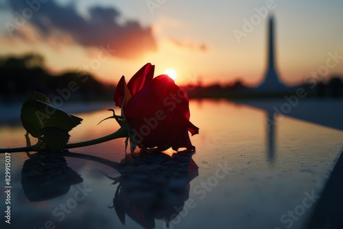 A single red rose adorning the Tomb of the Unknowns, capturing a silent tribute copy space, reflective honor, dynamic, silhouette against a dawn backdrop