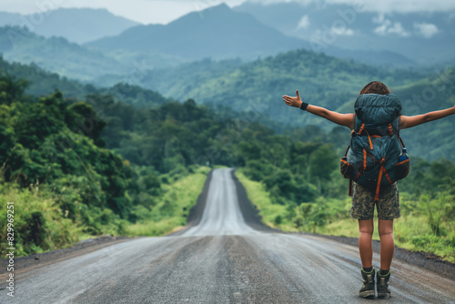 Young solo backpacker thumbing a ride on remote mountain road 