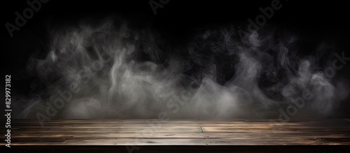 Dark background with an empty wooden table Smoke gently floating up creating an intriguing atmosphere Perfect for showcasing your products Copy space image