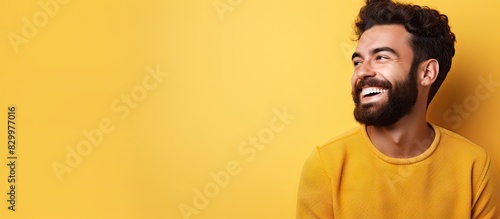 A friendly young man with a cool beard is happily smiling winking and exuding positive vibes in a copy space image