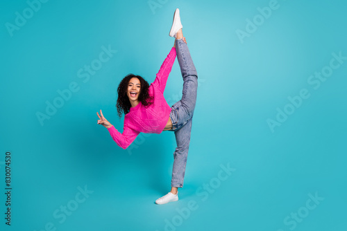 Full length photo of lovely teen lady flexible split v-sign dressed stylish pink garment isolated on cyan color background