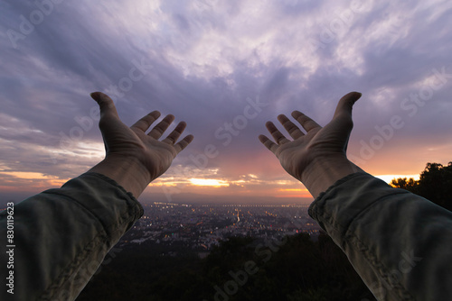 man raised her hands above her head to ask for mercy from God in accordance with her belief in God in Christianity. man raising both hands to ask for blessings from God according to beliefs