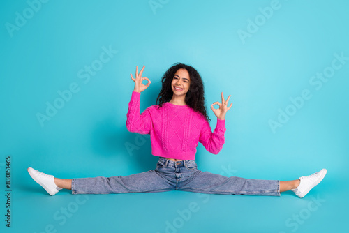 Full length photo of lovely teen lady sit floor split okey dressed stylish pink garment isolated on cyan color background