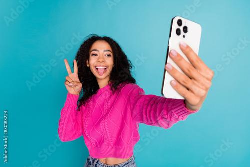 Photo portrait of lovely teen lady selfie photo v-sign stick tongue dressed stylish pink garment isolated on cyan color background