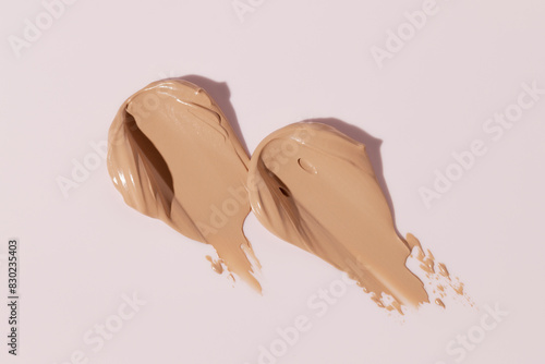 Makeup foundation, beige concealer swatch smudge smear on pink background. BB CC cream texture