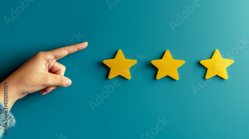 Hand gestures towards three yellow stars, symbolizing rating, quality, or achievement