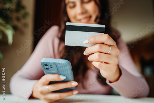 One young caucasian woman is buying online on her laptop using credit card from her home 