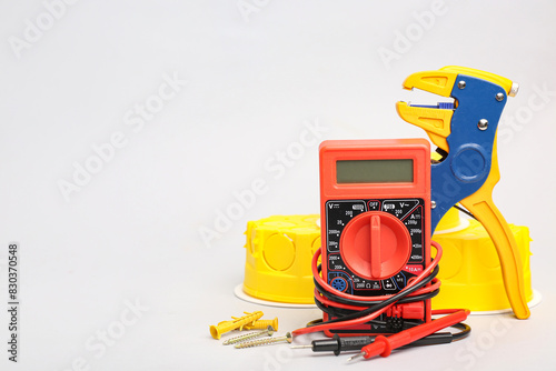 Set of electrician's tools with multimeter on light background