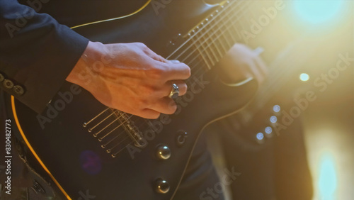 Music video with electric guitarists. Stock footage. Close-up of electric guitarists on background of sunlight. Bright sunlight with guitarists playing at rock concert