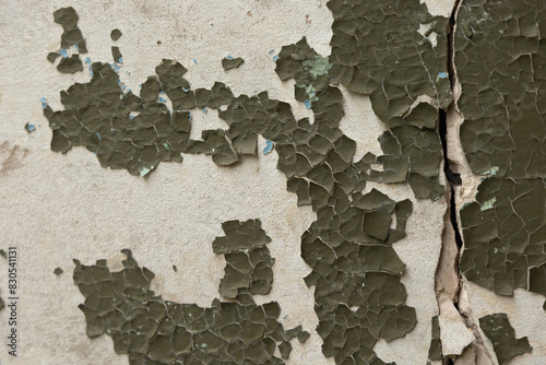 An old, pealed paint on the wall of abandoned building. Cracked paint texture.