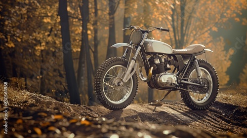 The image shows a scrambler motorcycle on a rocky hill. The motorcycle has a vintage look and is surrounded by trees.