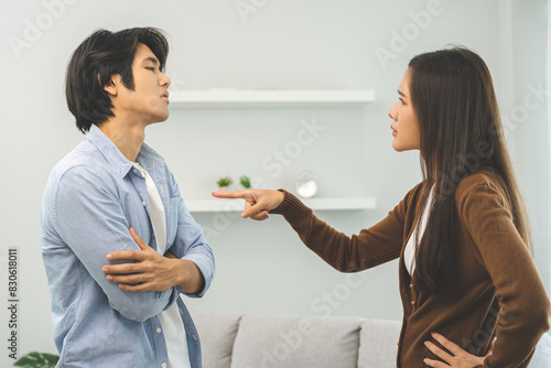 Asian young couple fight standing on white background, relationship in trouble. Different angry, use emotion shouting at each other. Argue husband has expression of disappointment and upset with wife.