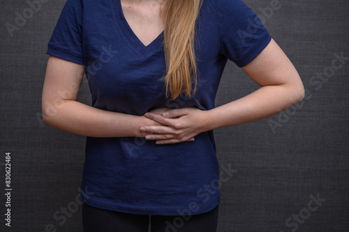 Ból brzucha po lewej stronie, kobieta trzyma się za brzuch
