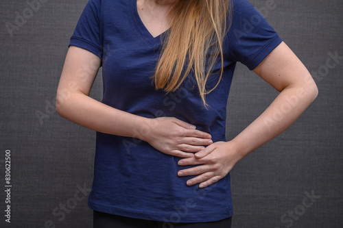 Ból brzucha z lewej strony, cierpiąca kobieta pokazuje gdzie boli