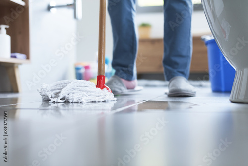 Woman cleaning up the floor with a mop
