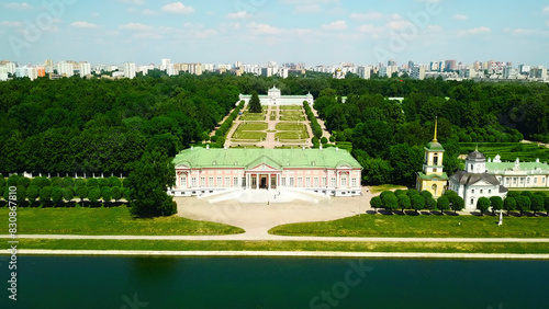 Palace with pond on background of modern city. Creative. Top view of beautiful historical complex on sunny summer day. Palatial buildings with garden and pond with contrast of modern city on horizon