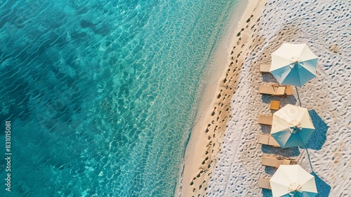 Aerial view of amazing beach with umbrellas and lounge chairs beds close to turquoise sea. Top view of summer beach landscape, idyllic inspirational couple vacation, romantic holiday. Freedom travel