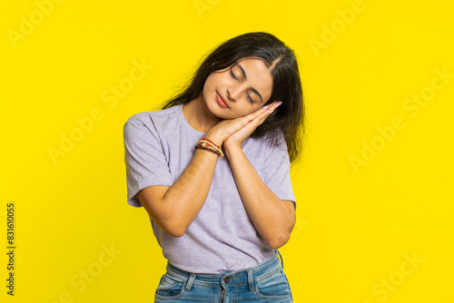 Tired exhausted Indian young woman yawning, sleepy inattentive feeling somnolent lazy bored gaping suffering from lack of sleep, falling asleep. Arabian Hindu girl isolated on yellow studio background