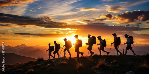 Silhouette of group of scouts hiking in mountains at sunset