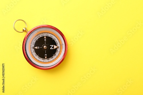 Compass on yellow background, top view. Space for text
