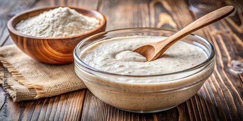 Close-up of sourdough starter in a bowl with a wooden spoon