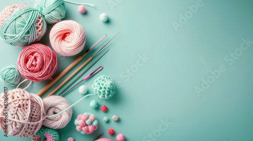 assorted knitting yarn and crochet tools on pastel teal background with copy space