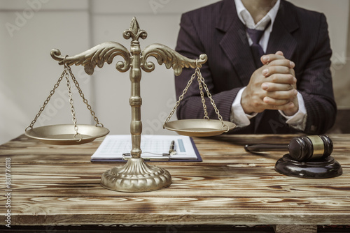 A businessman in a formal suit signs a contract, hands close up, suggesting possible bribery, at a wooden desk with legal documents, scales, and a wooden gavel representing legislation.