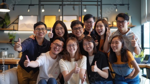 Group of Asia young creative people in smart casual wear smiling and thumbs up in creative office workplace. Diverse Asian males and females stand together at startup. Coworker teamwork concept.