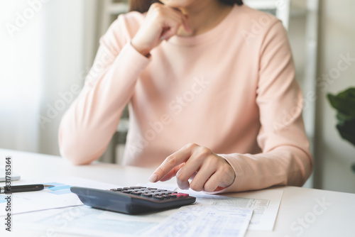 Deduction planning concept. Asian young woman hand using calculator to calculating balance prepare tax reduction income, cost budget expenses for pay money form personal Individual Income Tax Return