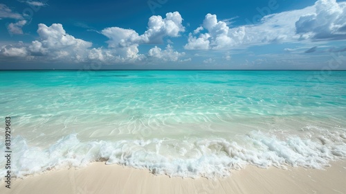 Crystal clear turquoise sea with gentle waves lapping the shore under a bright blue sky, perfect for a tropical escape