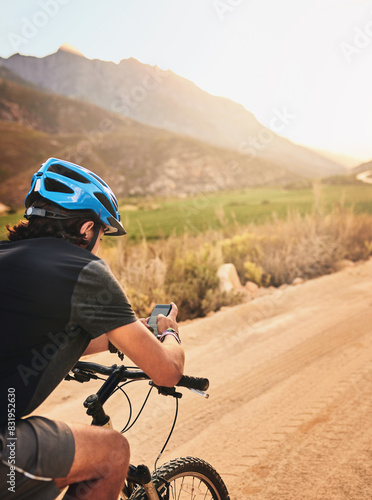 Nature, smartphone and man with bicycle for fitness, exercise and training for wellness or health. Back, male cyclist or cellphone for trail navigation, searching GPS or direction in countryside