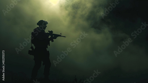 Silhouette of man with assault rifle on dark toned foggy background
