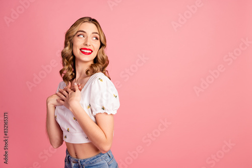 Photo portrait of lovely young woman touched look empty space dressed stylish white garment hairdo isolated on pink color background